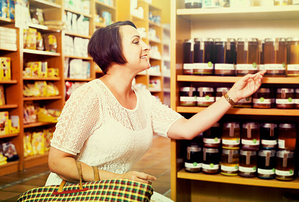 istock Woman choosing honey in store 590242928