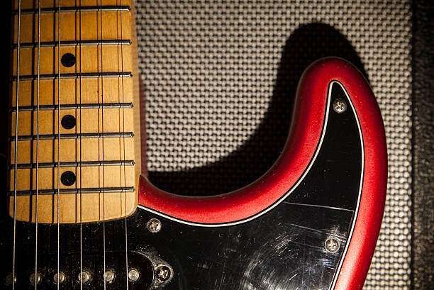 istock Black and red electric guitar over amplifier device 590244502