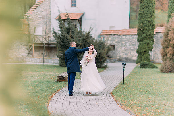 istock Charming newlywed couple at wedding day dance on green park 590247366