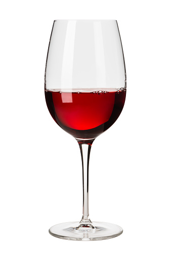 Pouring red wine into a glass isolated on white background. The wine is popping as it is pouring, the shot is slightly leant to the right.