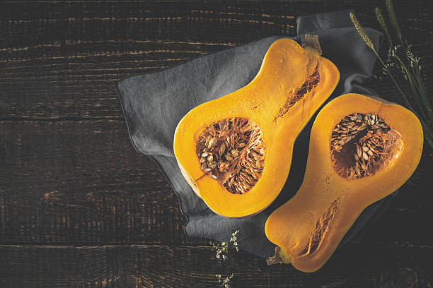 istock Pumpkin halves on the old wooden table top view 590250846