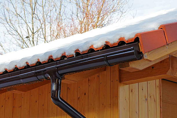 istock wooden roof with rain gutter and drainpipe in winter 590252346