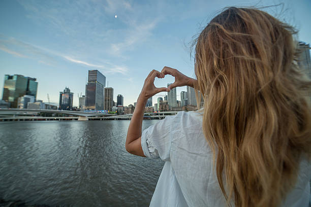 istock Caucasian female makes heart shape finger frame to Brisbane 590254966