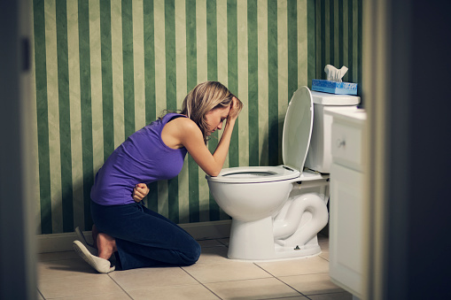 Sick young woman at toilet