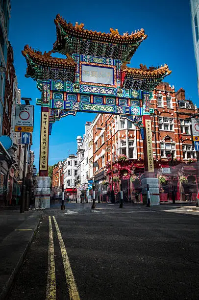 The Gate in chinatown, london, England with glazed yellow tiles, a golden dragon, painted panels, two white jade plaques and gold foil. The Chinese text translates ‘Peace and Prosperity to Chinatown’