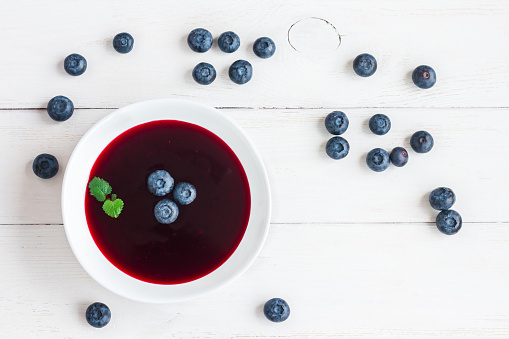 Blueberry soup on wooden white background. Top view, flat lay