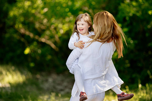 istock Baby with down sydrome enjoying outdoor play 590274320