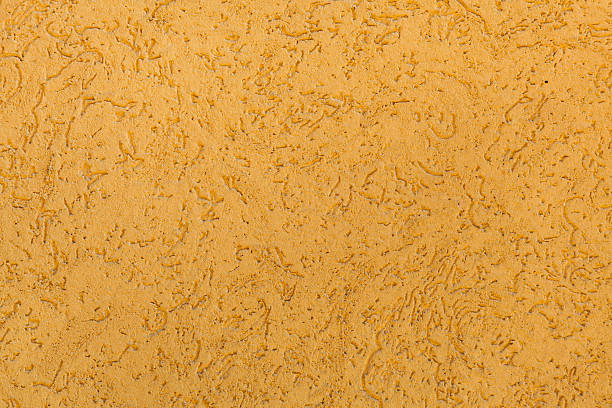 istock Yellow ochre painted stucco wall. Background texture 590274556