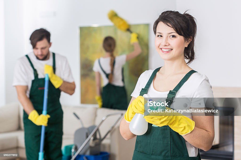 It's better to work in group Group of young hard working professional cleaners in dirty apartment Cleaner Stock Photo