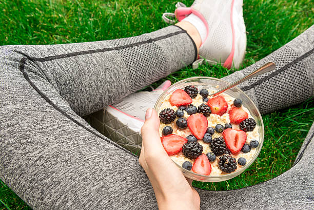 Young girl eating a oatmeal with berries. stock photo