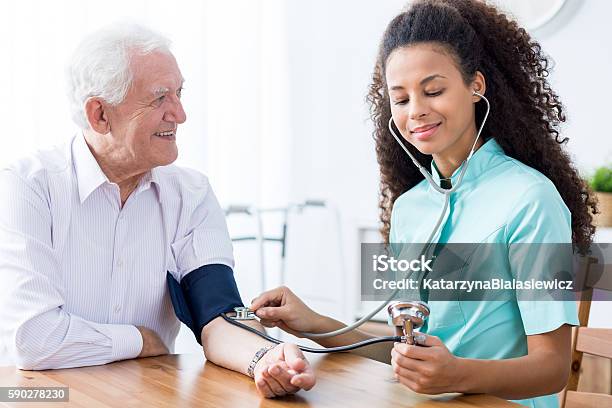 Professional Nurse Checking Patients Blood Pressure Stock Photo - Download Image Now