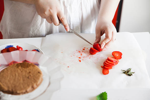 istock Woman Cutting Strawberries 590284476