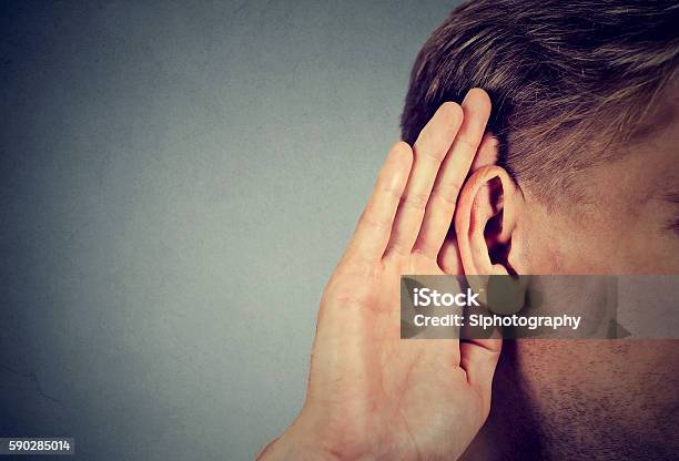 Man Holds Hand Near Ear And Listens Carefully Stock Photo - Download Image Now - Ear, Men, Whispering