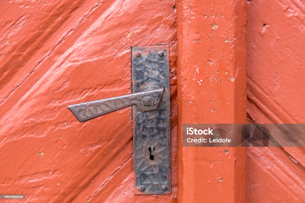 Door handle Red wooden door in Røros, Unesco mining town.  Aging Process Stock Photo