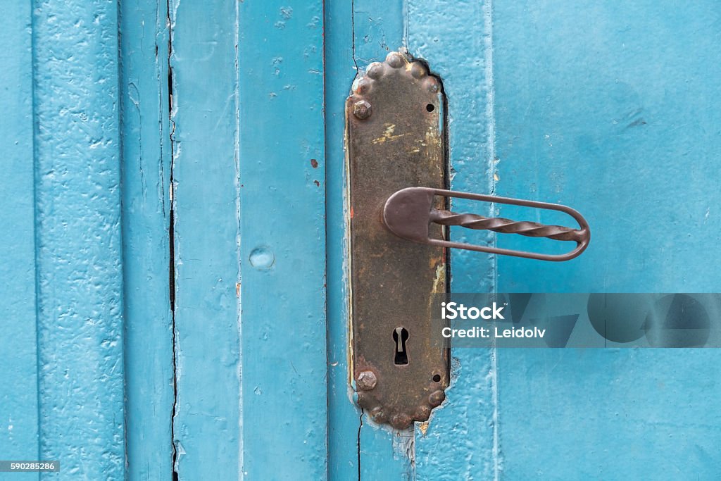 Door handle Blue wooden door in Røros, Unesco mining town.  Aging Process Stock Photo