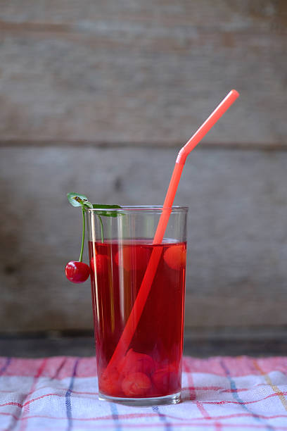 istock Glass of red cherry compot and some cherries 590286136