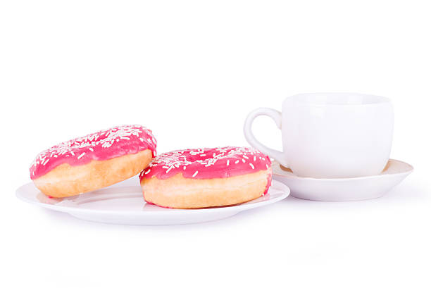 istock two pink donut on a plate next to cup 590287368