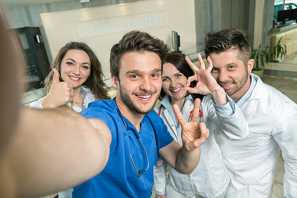 lächelndes team von ärzten und krankenschwestern im krankenhaus macht selfie - healthcare and medicine nurse doctor general practitioner stock-fotos und bilder