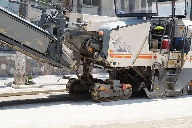 asphaltentfernen von maschinen, die pulverförmigen asphalt auf den lkw verladen - resurface stock-fotos und bilder