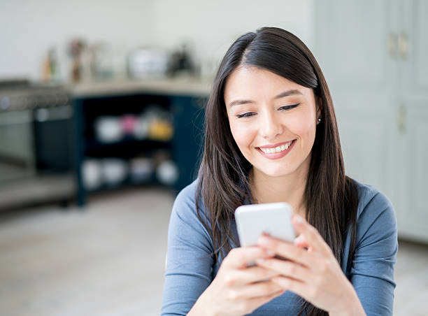 istock Latin American woman texting on her phone 590295722