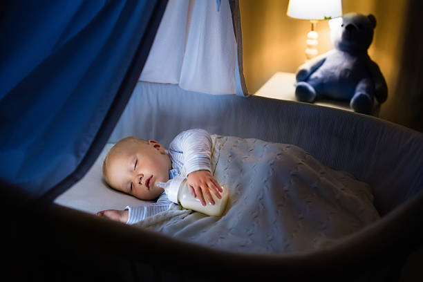 istock Baby boy drinking milk in bed 590295924