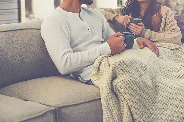 Photo of Couple drinking coffee on the sofa.