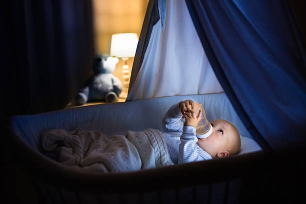 istock Baby boy drinking milk in bed 590298368