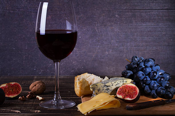 istock Red wine glass with fruits, cheese, figs and nuts 590298468