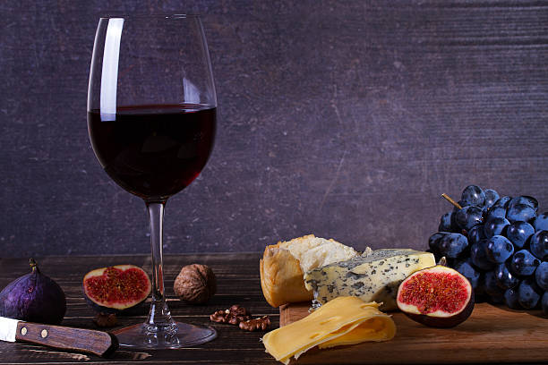 istock Red wine glass with fruits, cheese, figs and nuts 590298544