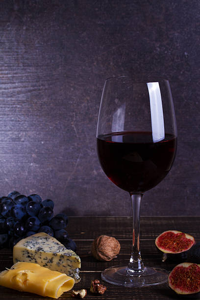 istock Red wine glass with fruits, cheese, figs and nuts 590298662