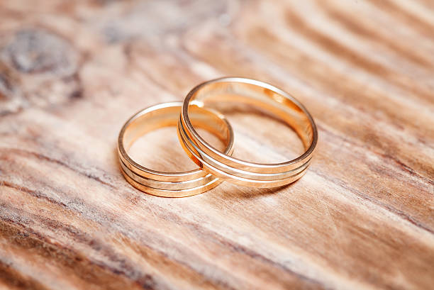 istock Two beautiful wedding rings on wooden background, close up 590302176