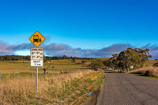 strada dell'entroterra australiana con cartello della fermata dello scuolabus - entroterra foto e immagini stock