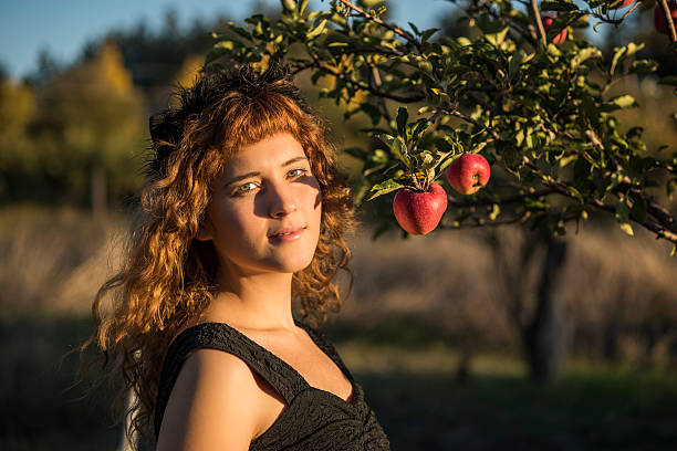 istock Young woman as cat on Halloween picking apples from trees 590303700