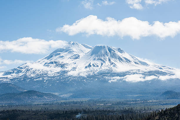 Snowcapped Mount Shasta volcano during winter Snowcapped Mount Shasta volcano during winter with valley view and clouds on mountain mt shasta photos stock pictures, royalty-free photos & images