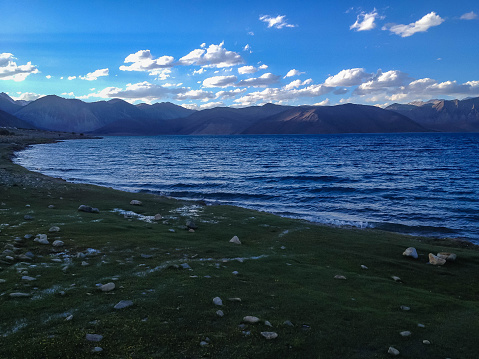 Mountains and Pangong tso (Lake). It is huge lake in Ladakh, with snow peaks and blue sky in background, it extends from India to Tibet. Leh, Ladakh, Jammu and Kashmir, India