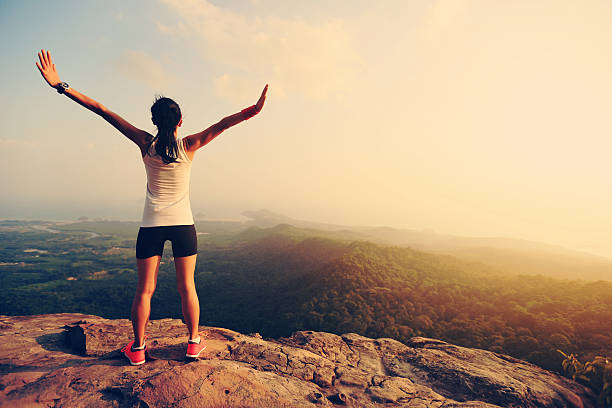 istock young successful woman open arms on mountain peak 590580554