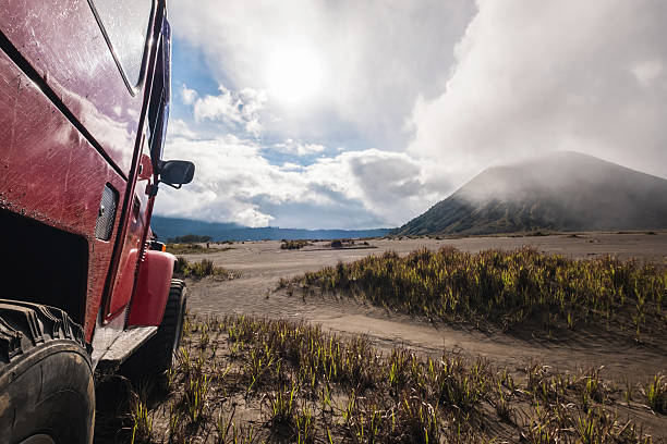 voiture hors route rouge à la montagne bromo, essai d’aventure - sports utility vehicle 4x4 car mud photos et images de collection