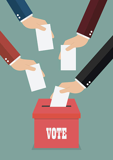 istock Businessmen putting papers in the ballot box 590583530