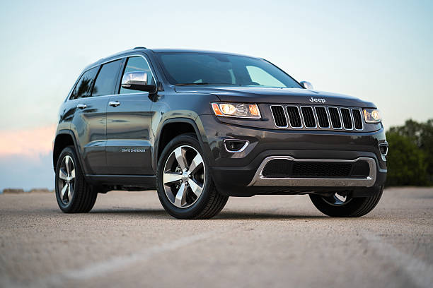 Graphite Jeep Grand Cherokee Limited 2016 Miami, USA - August 18, 2016: Graphite Jeep Grand Cherokee Limited 2016 SUV on a parking lot close to the sea 2016 stock pictures, royalty-free photos & images