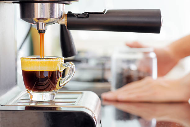 Espresso coffee machine in kitchen. Coffee pouring into cup Espresso coffee machine in kitchen. Jets of hot invigorating coffee pouring into cup. espresso maker stock pictures, royalty-free photos & images