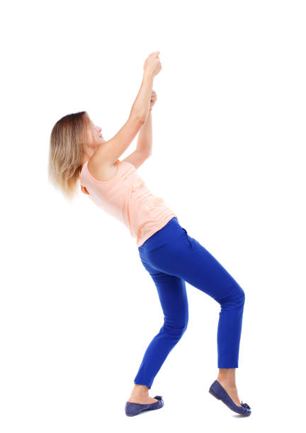istock back view of standing girl pulling a rope from top 590586814