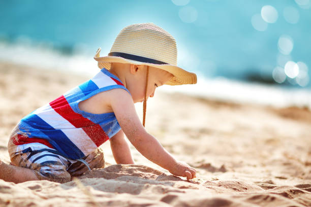 istock little boy playing at the beach in straw hat 590587604