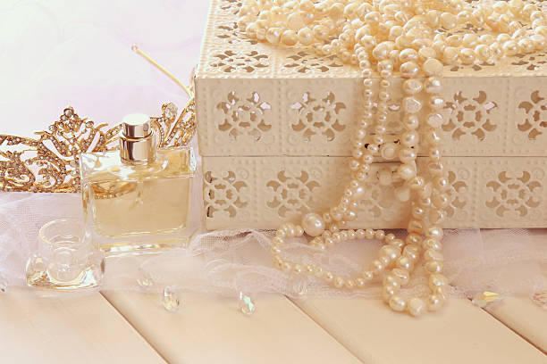 istock White pearls necklace, diamond tiara and perfume bottle 590588262