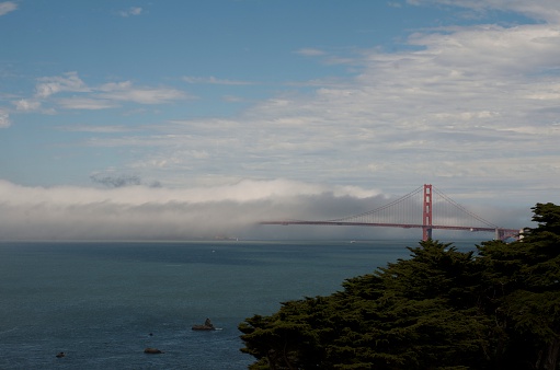 Taken from Lands End San Francisco. The fog rolled in and covered half of the bridge and left the San Francisco side clear