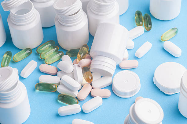 istock Many pills and tablets isolated on light blue background 590591456