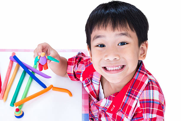 istock Asian child show his works from clay, on white background. 590592956