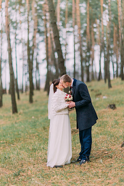 istock Cute white dressed bride with her handsome groom kissing in 590593448