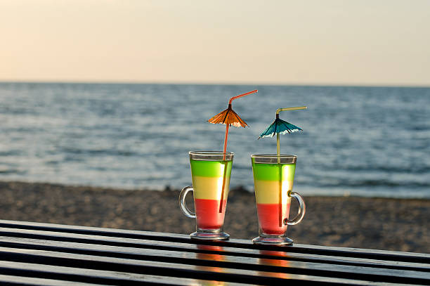 due cocktail con cannucce sulla spiaggia - umbrella two objects cocktail drink foto e immagini stock