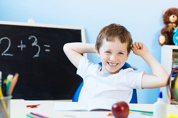 istock Happy seven years old boy in classroom 590598616