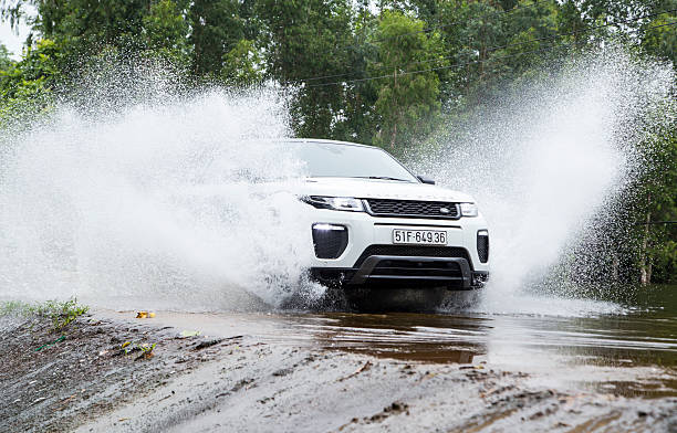 Range Rover Evoque 2016 car Hanoi, Vietnam - July 13, 2016: Range Rover (Land Rover) Evoque 2016 car crossing water dam on the test road in mountain area in Vietnam. evoque stock pictures, royalty-free photos & images